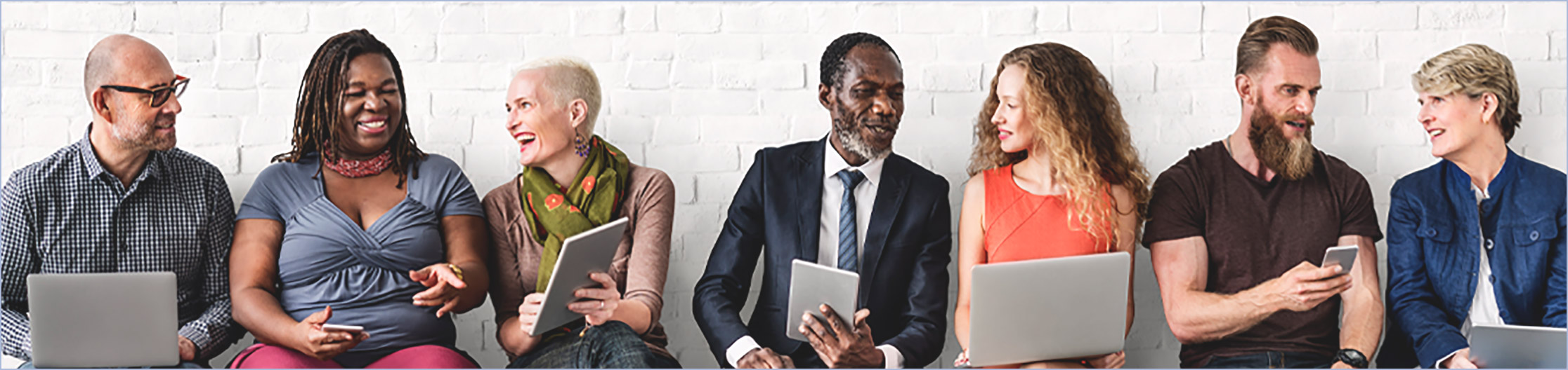 A group of people sitting on a bench networking.