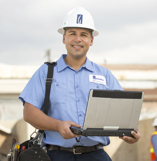 Someone holding their laptop smiling.