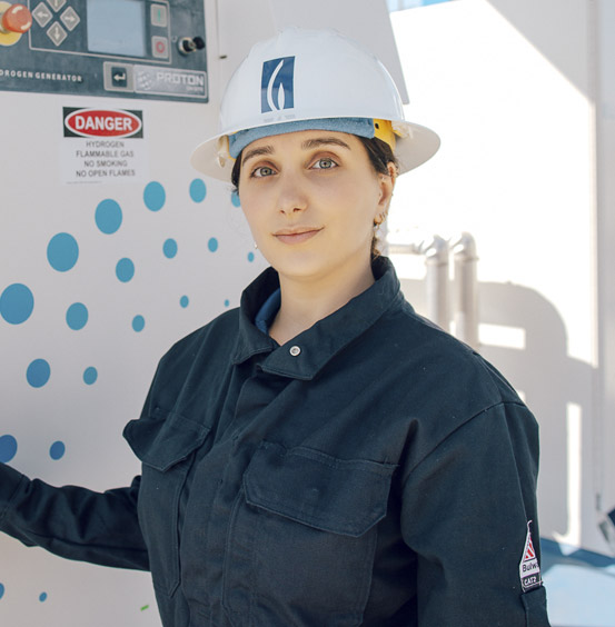 Someone standing next to a generator smiling.