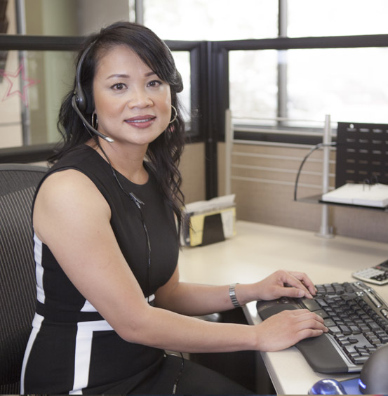 Someone sitting at their desk smiling.