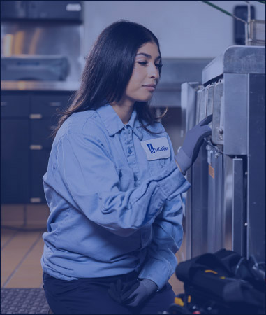 Picture. An employee working on a customer's stove.