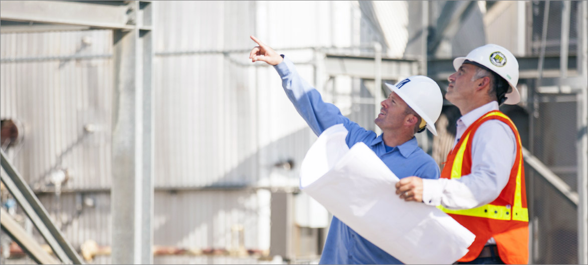 Picture. Two employees working on a jobsite.