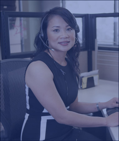 Picture. An Employee sitting at their desk smiling.